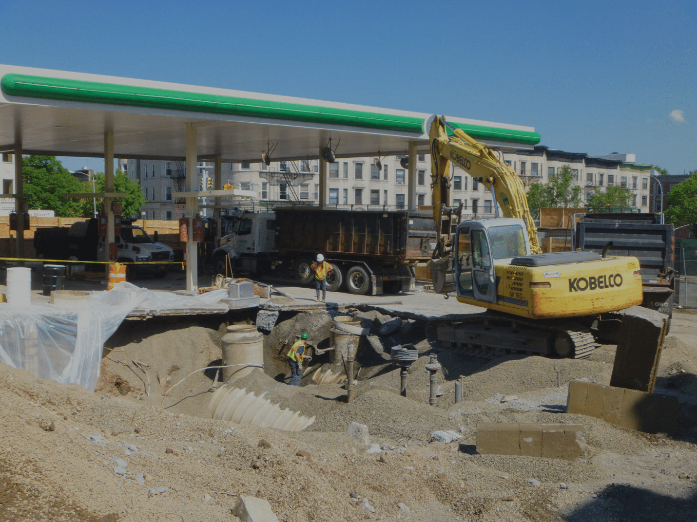 Excavator removing an undergound storage tank at a gas station 
